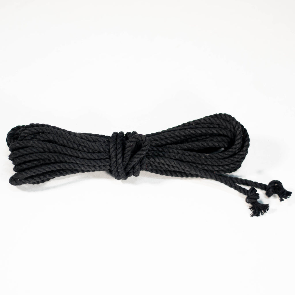 A coiled black cotton rope with knots on the end, displayed on a white background.
